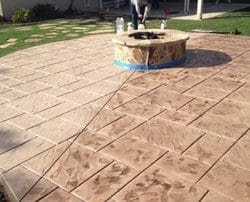 alt="stamped concrete pack yard patio and fire pit installation, concrete color staining and sealing with water base sealer."