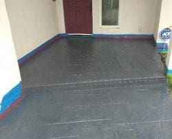 alt="front entrance slab concrete installation and colored with grey staining and water base sealer"